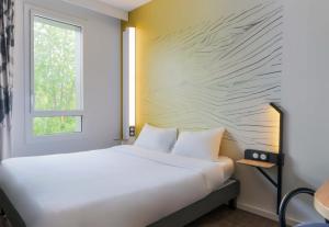 a bedroom with a bed and a window at B&B Hôtel Thionville Centre Gare Porte du Luxembourg A31- Confort climatisé in Thionville