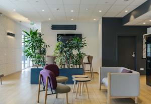 a lobby with chairs and plants at B&B Hôtel Thionville Centre Gare Porte du Luxembourg A31 in Thionville