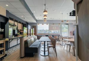 a restaurant with tables and chairs and a bar at B&B Hôtel Thionville Centre Gare Porte du Luxembourg A31- Confort climatisé in Thionville