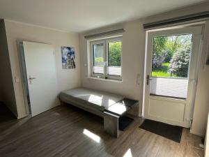 a room with a bench in front of two windows at Hempen Fied Gästehaus - Apartment 3 in Bad Zwischenahn
