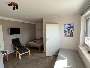a small room with a bed and a chair at Hempen Fied Gästehaus - Apartment 3 in Bad Zwischenahn