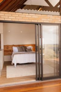 a bedroom with a bed inside of a house at Chalé Além do Horizonte in Bom Repouso