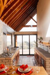 a kitchen with a table and a large window at Chalé Além do Horizonte in Bom Repouso