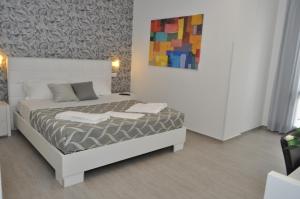 a bedroom with a bed with a painting on the wall at Hotel Sikania in San Vito lo Capo