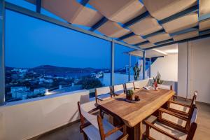 a dining room with a table and chairs and a large window at Syrrho's in Vari