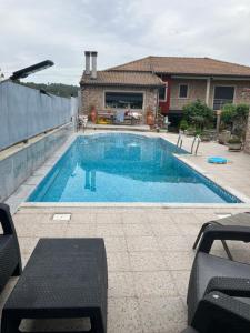 a swimming pool in front of a house at Casa da Pizzaria in Carapito