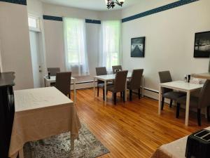 a dining room with tables and chairs in it at Andy's Blue House in Charlottetown