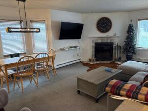 a living room with a couch and a table and a fireplace at Pico F101 in Killington