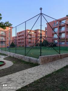 a tennis court with a net in front of some buildings at Family Studio flat in Tŭnkovo