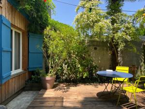 un patio avec une table et des chaises à côté d'un bâtiment dans l'établissement Mirabelle Second, à Bagnères-de-Bigorre