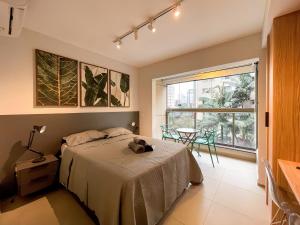 una camera da letto con un letto, un tavolo e una finestra di Belint Bela Cintra: A 5 Minutos da Paulista com Piscina no Rooftop a San Paolo Altre 221 foto