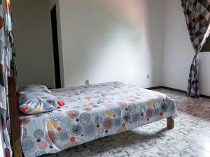 a bedroom with a bed with a flowered blanket at Casa com Wi-Fi proximo a Ilha de Itaparica in Ponta da Areia