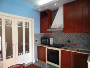uma cozinha com armários de madeira e um micro-ondas em Forty One em Marsala