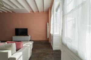 a living room with a couch and a tv at La Bonbonnière maison de ville 10 personnes in Sanxay +52 photos