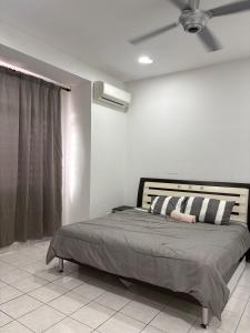 a bedroom with a bed with a ceiling fan at Putra Impiana Puchong in Puchong