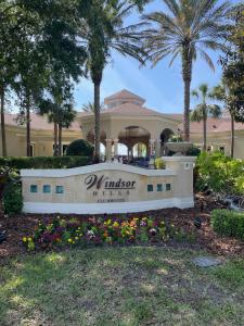 un cartello di fronte a un edificio con palme di Family Friendly II a Orlando