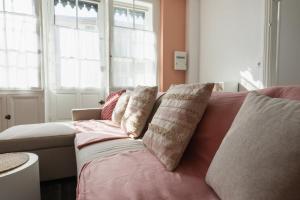 a couch with pillows on it in a living room at La Bonbonnière maison de ville 10 personnes in Sanxay