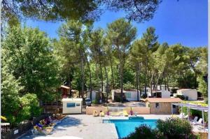 a backyard with a swimming pool and trees at ZEcamping 3 étoiles toboggans piscine locatif 25m2 5 pers in Peynier