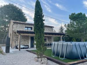 a stone house with a tree in front of it at Cabana Blanca Turisme Rural in Solsona