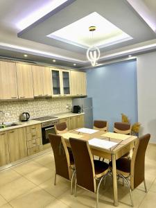uma cozinha com mesa e cadeiras num quarto em Chloe Apartament em Berati