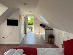 a room with a bed and a kitchen with a television at Rubys cartlodge in Stambourne