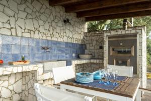 a table with wine glasses and a stone wall at Villa Il Basto 8 by Massimo Villas in SantʼAmbrogio
