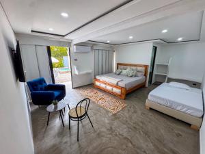 a bedroom with two beds and a blue chair at Teka Hotel Villavicencio in Apiay +7 photos