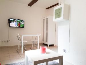 a living room with a table and a tv on the wall at Le panier centre historique de marseille in Marseille