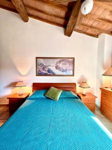 a bedroom with a blue bed with two lamps at Le Case Vacation Home in Casa Coldi Sasso