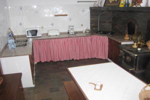 a kitchen with a table with a red and white table cloth at Pátio Mateus in Areia Branca