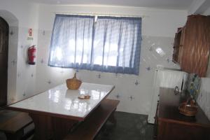 a kitchen with a counter and a window and a refrigerator at Pátio Mateus in Areia Branca
