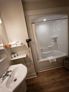 a bathroom with a sink and a bath tub at Birch Woods House in Stratford +55 photos