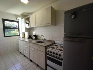 a kitchen with a black refrigerator and a stove at Amado Sur Apartment in San Carlos de Bariloche +17 photos