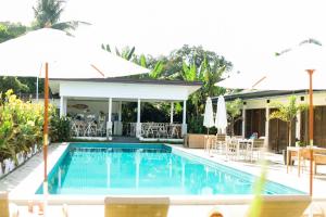 a pool with chairs and umbrellas at a resort at Canna Boutique Hostel in Panglao Island