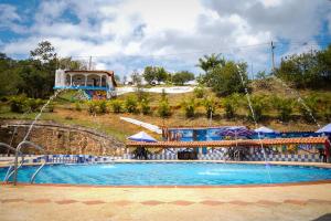 a large swimming pool with a water fountain at Hotel Hacienda Rincon del Cielo in Curití