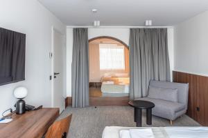 a room with a bed and a chair and a bedroom at AIRINN Vilnius Airport Hotel RENOVATED 2025 in Vilnius