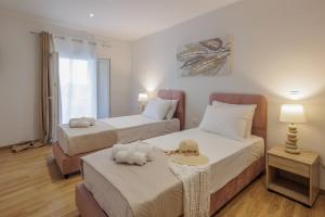 a bedroom with two beds and a table in it at Pavlos & Sofia Villa Vigla - Heated Private Pool in Ágios Matthaíos