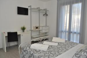 a white room with a table with towels on it at Hotel Sikania in San Vito lo Capo