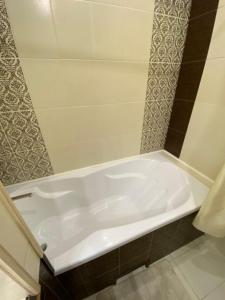 a white bath tub sitting in a bathroom at Zacahry Apartments in Helsinki