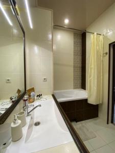 a bathroom with a tub and a sink and a shower at Zacahry Apartments in Helsinki