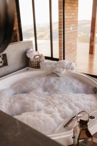 a bath tub filled with lots of white bubbles at Chalé Além do Horizonte in Bom Repouso +33 photos