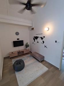 a living room with a ceiling fan and a television at HomieDahlia Homestay Minimalist Live simply in Pasir Gudang
