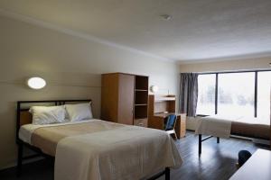 a hotel room with two beds and a window at Residence & Conference Centre - Sarnia in Sarnia