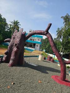 a statue of a tree stump with a face on it at ZEAL HOMES AND APARTMENTS 2 KOOTHATTUKULAM in Kuttāttukulam +28 photos