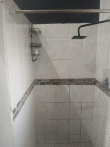a white tiled bathroom with a shower in it at Melee's house in Richards Bay