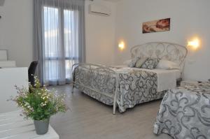a bedroom with a bed and a couch and a table at Hotel Sikania in San Vito lo Capo