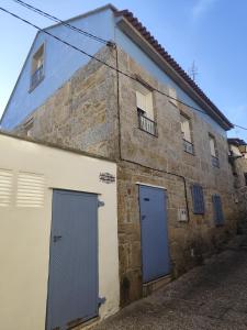 stary kamienny budynek z dwoma niebieskimi drzwiami w obiekcie Casa O Castriño w mieście Cambados +37 zdjęć