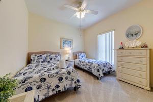 a bedroom with two beds and a dresser and a fan at Tuscan Pines Villa in Davenport +69 photos