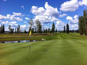 un campo de golf con bandera amarilla en el green en Prince Motel en Prince George