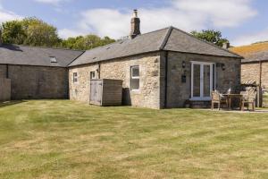 een stenen huis met een tuin ervoor bij Lyme Grass in Bamburgh